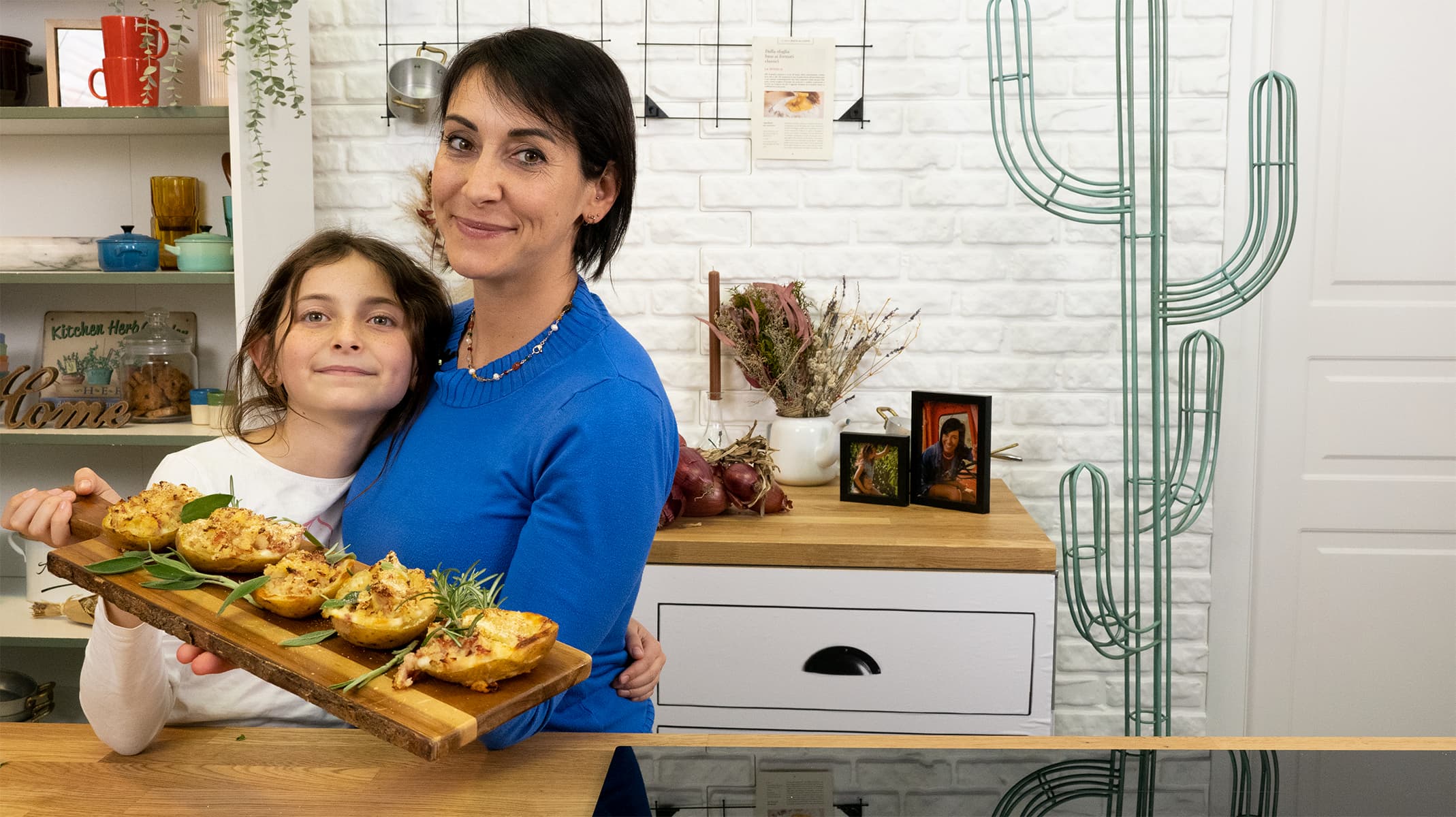Erica Liverani e sua figlia Emma che reggono un vassoio pieno di patate al forno ripiene nella Country House video